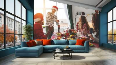 company of cheerful and happy friends celebrating at christmas dinner Wall mural