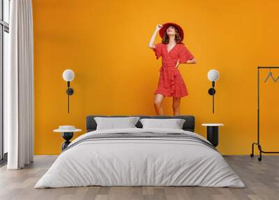 concept happy emotional young woman in red summer dress and hat jumping   on yellow background. Wall mural