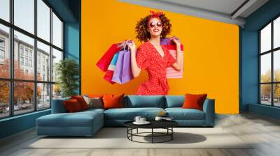 concept of shopping purchases and sales of happy   girl with packages  on yellow background. Wall mural