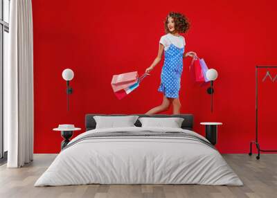 concept of shopping purchases and sales of happy young girl with packages  on yellow background. Wall mural