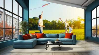 Dad, mom and son child flying a kite in summer nature Wall mural