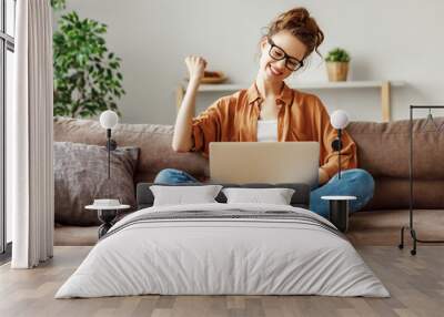 Delighted young woman celebrating victory in online lottery Wall mural