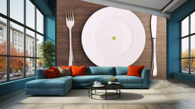 diet concept. one pea on an empty white plate Wall mural