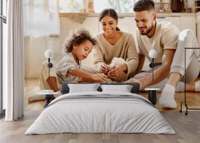 Diverse parents playing with son in kitchen. Wall mural