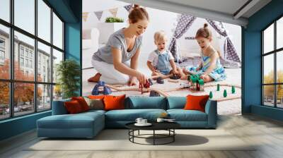 family mother and children play a toy railway in   playroom Wall mural