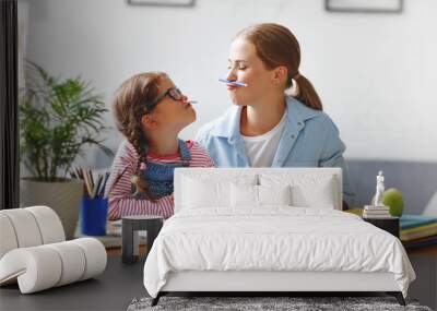 funny mother and child daughter doing homework writing and reading Wall mural