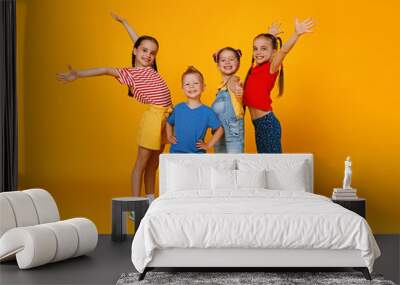 group of cheerful happy children on colored yellow background. Wall mural