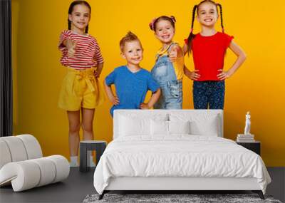 group of cheerful happy children on colored yellow background. Wall mural