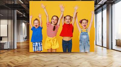 group of cheerful happy children on colored yellow background. Wall mural