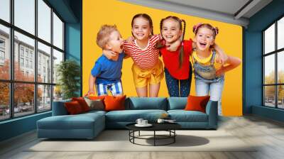 group of cheerful happy children on colored yellow background. Wall mural