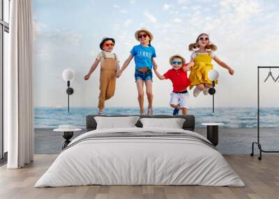 group of happy children jump by   sea in summer Wall mural