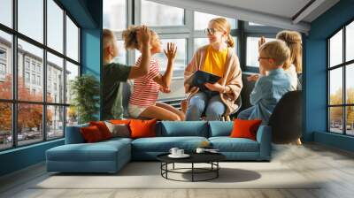 Group of schoolchildren raise their hand looking at the teacher to answer in class  during psychological training,   therapy or  creative task Wall mural