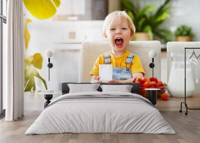 happy baby boy eating strawberries with milk Wall mural