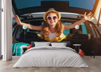 happy child girl in car going on summer vacation trip. Wall mural