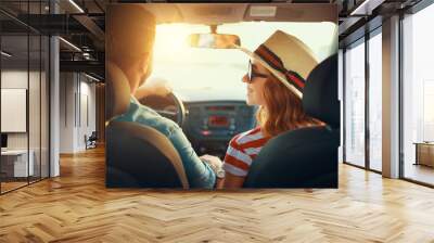 happy couple man and woman in car traveling in summer. Wall mural