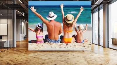 happy family father, mother and children backs on  beach at sea. Wall mural