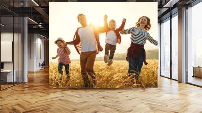 Happy family father of mother and child son  on nature at sunset Wall mural