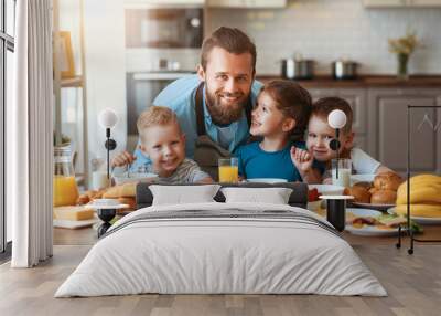 happy family father with children feeds his sons and daughter in kitchen with Breakfast. Wall mural