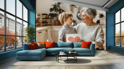 happy family grandson child congratulates grandmother on holiday and gives card Wall mural