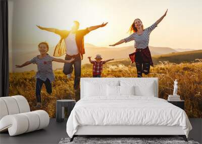 Happy family: mother, father, children son and daughter on sunset. Wall mural