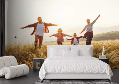 Happy family: mother, father, children son and daughter on sunset. Wall mural