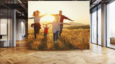 Happy family: mother, father, children son and daughter on sunset Wall mural