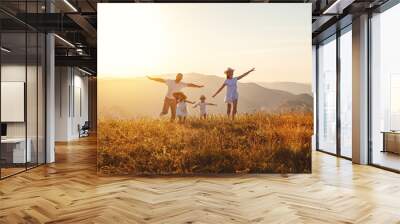 Happy family: mother, father, children son and daughter on sunset Wall mural