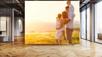 Happy family: mother, father, children son and daughter on sunset Wall mural