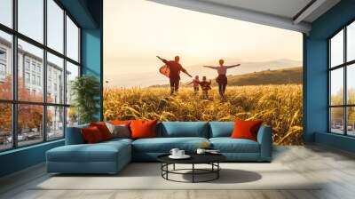 Happy family: mother, father, children son and daughter runing and jumping on sunset Wall mural