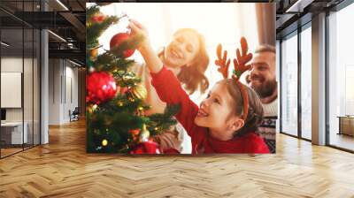 happy family mother, father and child daughter decorate Christmas tree  . Wall mural