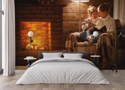 happy family mother and child daughter read book on winter evening near fireplace Wall mural