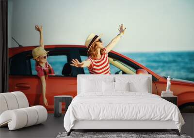 happy family mother and child girl goes to summer travel trip in car. Wall mural