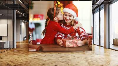 happy family mother and child pack Christmas gifts at home near Christmas tree Wall mural