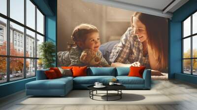 happy family mother and daughter read a book in evening Wall mural