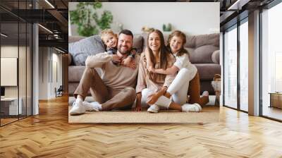 happy family mother father and children at home on couch . Wall mural