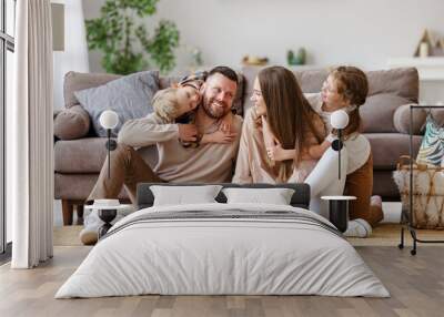 happy family mother father and children at home on floor next to sofa. Wall mural