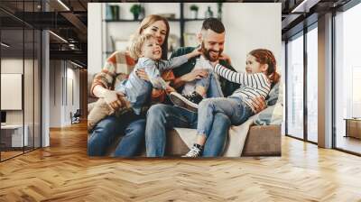 happy family mother father and kids at home on couch . Wall mural