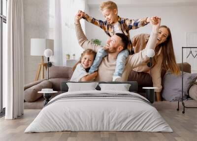 happy family mother father and kids having fun at home on couch . Wall mural