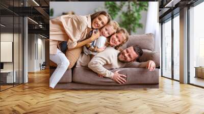 happy family mother father and kids having fun at home on couch . Wall mural