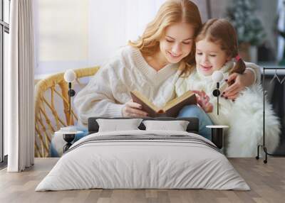 happy family mother reads book to child to daughter by window Wall mural