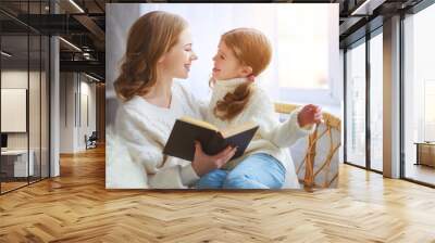 happy family mother reads book to child to daughter by window Wall mural