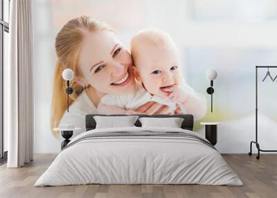 happy family mother  with baby playing and hug in bed Wall mural