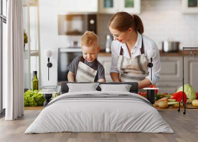 happy family mother with child son preparing vegetable salad . Wall mural