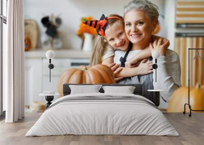 Happy granddaughter and grandmother preparing for Halloween celebration. Wall mural