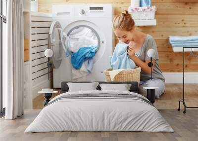 Happy housewife woman in laundry room with washing machine  . Wall mural