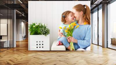 Happy mother's day! Child daughter congratulates moms and gives her a postcard and flowers Wall mural