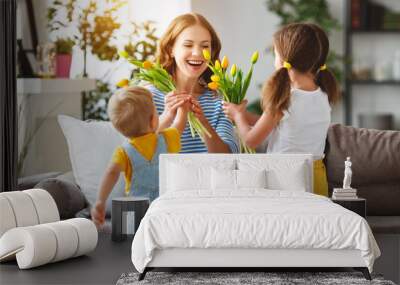 Happy mother's day! Children congratulates moms and gives her a gift and flowers Wall mural