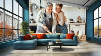 Happy mother and daughter preparing healthy food at home Wall mural