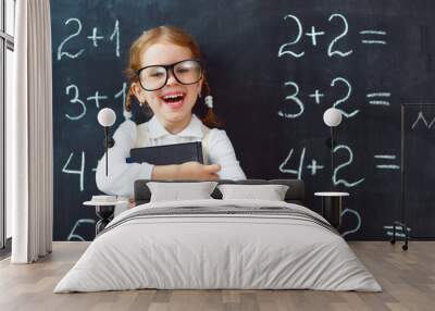 Happy schoolgirl preschool girl with book near school blackboard Wall mural