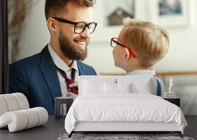 happy son helps father tie a necktie at home. Wall mural